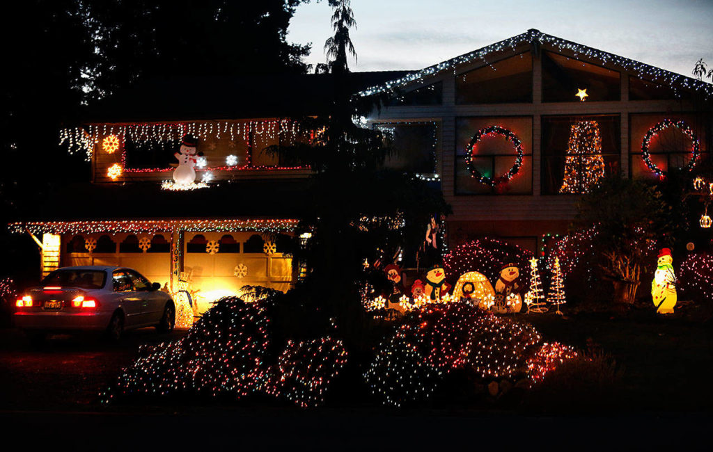 Jackie Noble pulls her car into her driveway as the light fades in the west. She has lived in Everett’s Fir Grove neighborhood since 1976. Her brightly lit house is just across the street from the neighborhood park where Santa collects food and cash donations for Volunteers of America until Christmas. (Dan Bates / The Herald)
