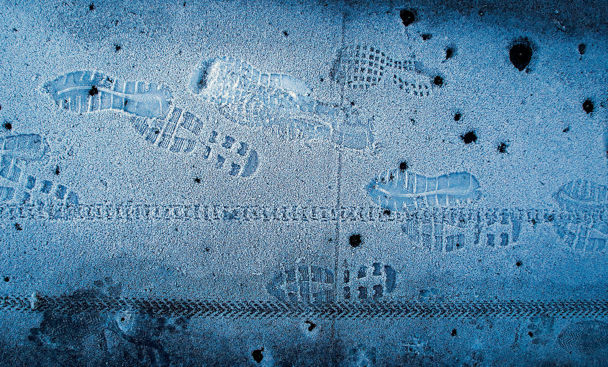 All the footprints on the frost-coated sidewalk of a W. Mukilteo Boulevard bridge over Merrill and Ring Creek on Monday morning appear to be from people heading south. (Dan Bates / The Herald)