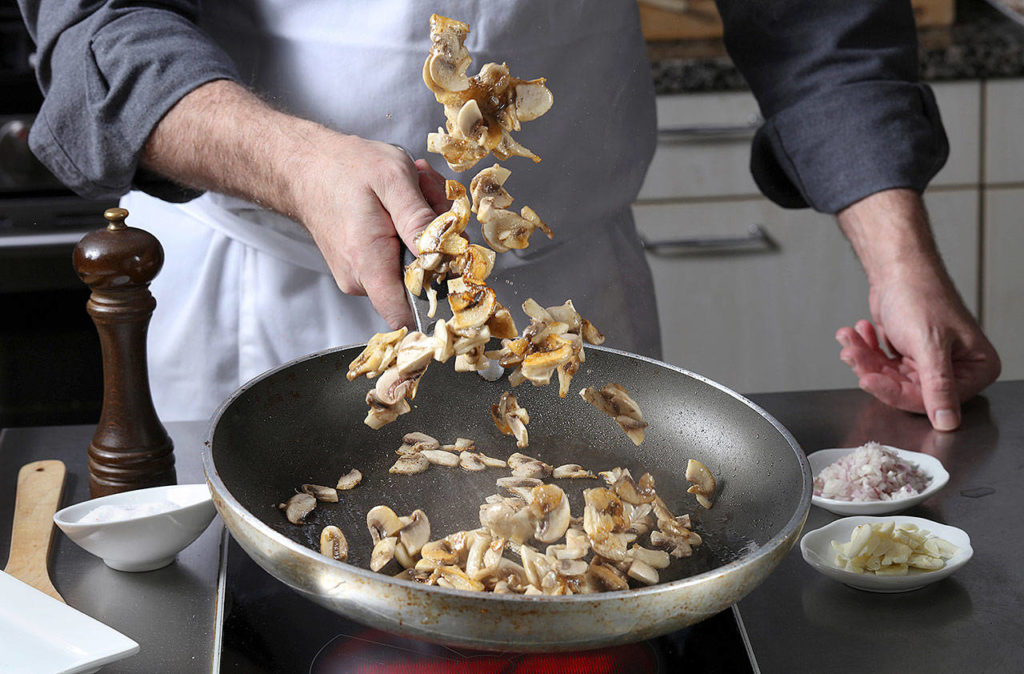 When your mushrooms are nicely seasoned and brown on the bottom, toss or stir them in the pan. (Abel Uribe/Chicago Tribune)
