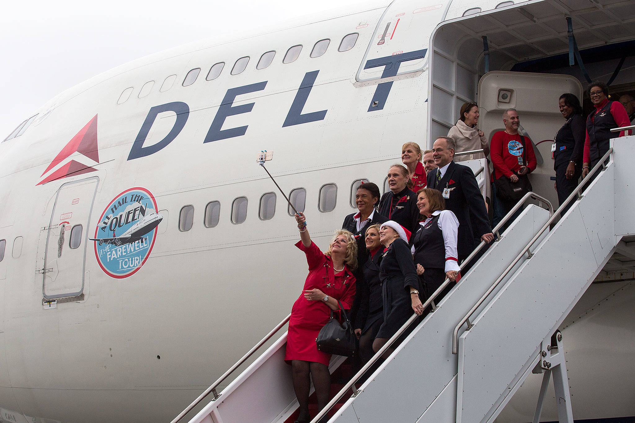 Members of a Delta Air Lines 747 flight crew pose for a photo after arriving at the Future of Flight Aviation Center at Paine Field during a stop on the plane’s a farewell tour on Monday. (Andy Bronson / The Herald)