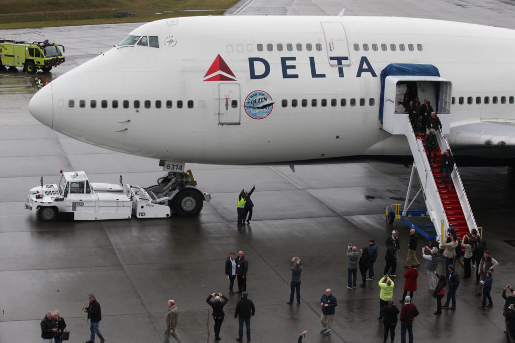VIPs, Delta Air Lines employees and other passengers disembark from o0ne of the airline’s last 747s at the Future of Flight Aviation Center at Paine Field during a stop on the plane’s a farewell tour on Monday. (Andy Bronson / The Herald)
