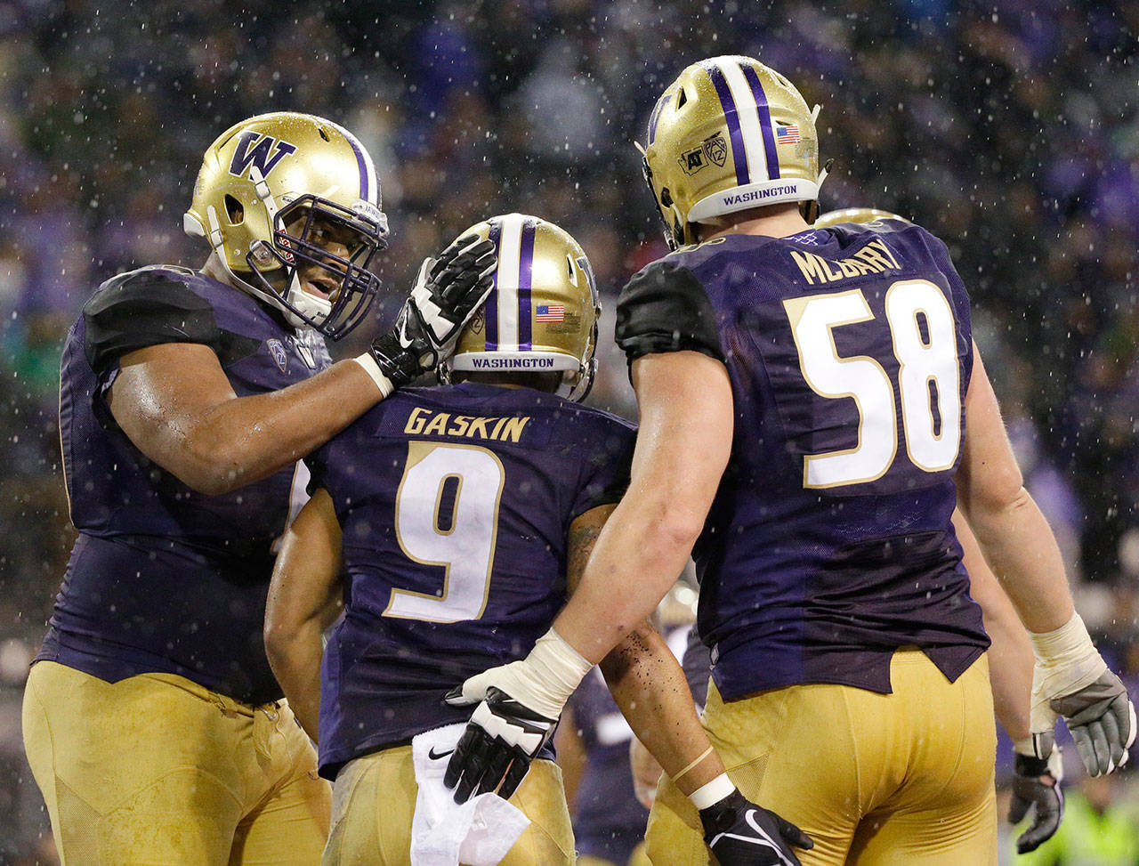 Washington running back Myles Gaskin (9) is greeted by offensive linemen Andrew Kirkland (left) and Kaleb McGary (right) after Gaskin scored a touchdown against Washington State during the second half of the Apple Cup on Nov. 25, 2017, in Seattle. (AP Photo/Ted S. Warren)