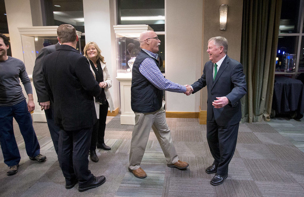 As a line forms, Mayor Ray Stephanson (right) smiles as he and Mike Deller shake hands before a farewell celebration for the mayor in the Ed Hansen Conference Center at Xfinity Arena on Dec. 12 in Everett. (Andy Bronson / Herald file)
