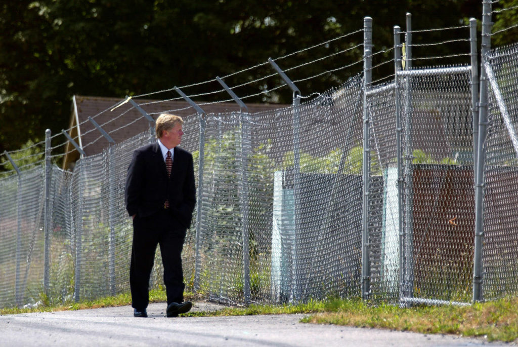Between rows of chainlink fence topped with barbed wire, Mayor Ray Stephanson walks down a longtime quarantined street in the infamous ASARCO cleanup area in north Everett on June 15, 2004. (Dan Bates / Herald file)
