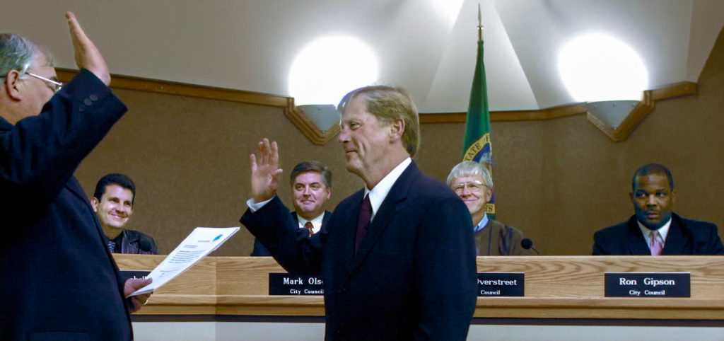 As City Council members watch in the background, Ray Stephanson is sworn in as mayor of Everett on Nov. 19, 2003, at the City Council Chambers by Municipal Court Judge Timothy O’Dell. The council members (from left) were Doug Campbell, Mark Olson, Bob Overstreet and Ron Gipson. (Herald file)
