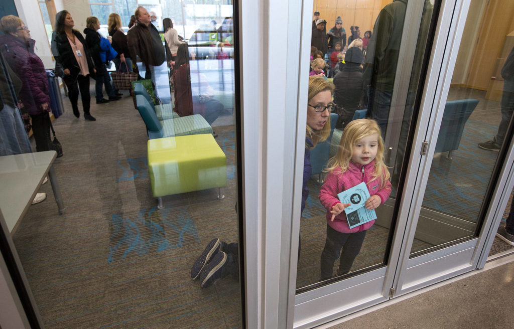 Upon arriving, Lacey Bogart and daughter Isla, 3, look toward the gym during an open house for students and parents at the new Lake Stevens Early Learning Center on Friday in Lake Stevens. (Andy Bronson / The Herald)
