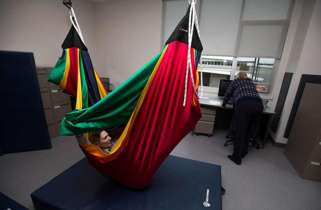 Speech Therapist Emily Million tries to get herself out of a hammock in the occupational therapy room during an open house for students at the new Lake Stevens Early Learning Center on Friday in Lake Stevens. (Andy Bronson / The Herald)
