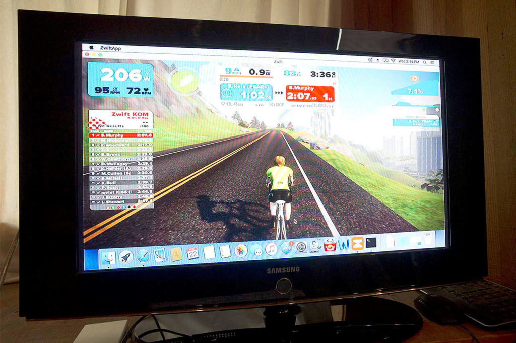 Zwift, a virtual cycling program, allows indoor cyclists, riding on trainers or stationary bikes, to compete with other cyclists across the globe in simulated races. Here, Oregonian Erin Reis has customized her avatar to sport a simiarly athletic haircut. She competes in an all-women criterium race every Saturday at 4:30 a.m. before work. (Ryan Brennecke/Bulletin photo)
