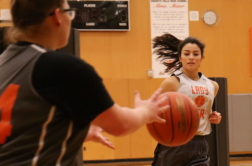 Granite Falls’ Sadie Hutchinson (left) receives a pass from Jenny Rodenbaugh during practice on Dec. 19, 2017, at Granite Falls High School. (Kevin Clark / The Herald)
