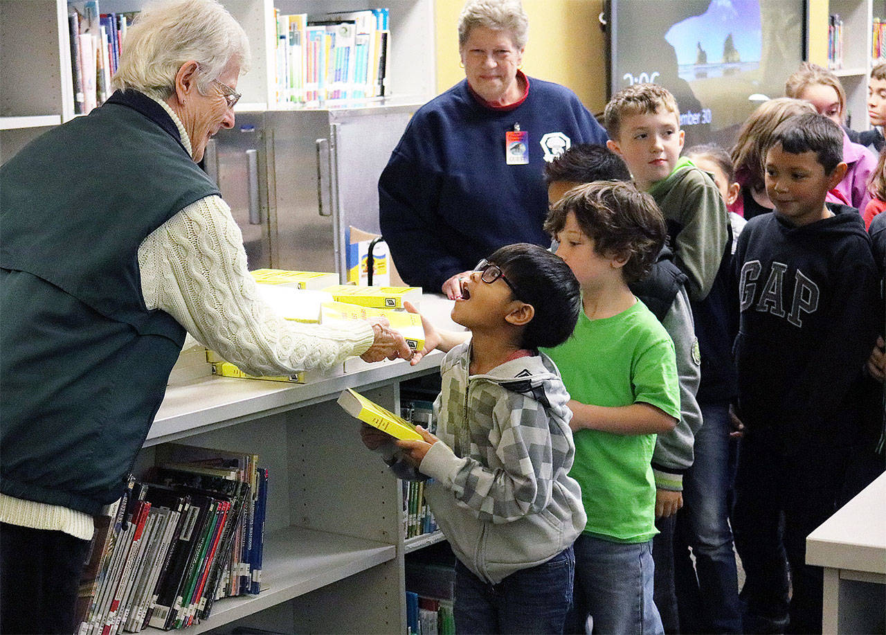 Fryelands Elementary School third-grader Tristin Phongsynha reacts to receiving his own new dictionary from Tualco Grange volunteer Margaret Ohlsen. (Contributed photo)
