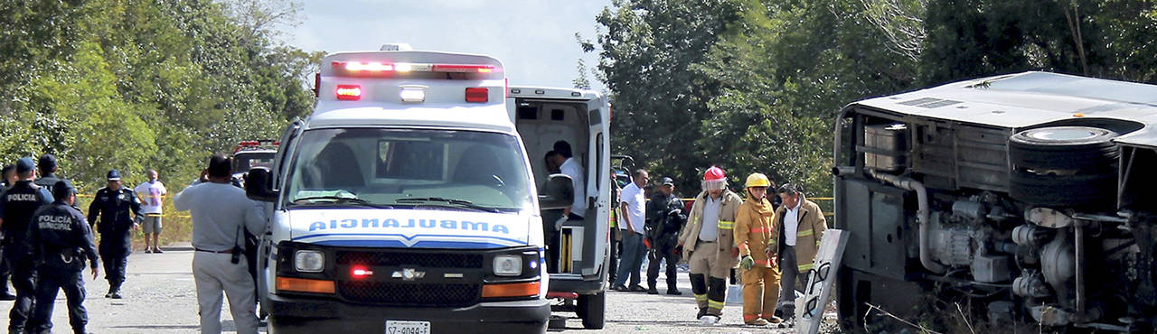 Ambulances, firefighters and police stand by a bus accident in Mahahual, Quintana Roo state, Mexico, on Tuesday. (Novedades de Quintana Roo via AP)