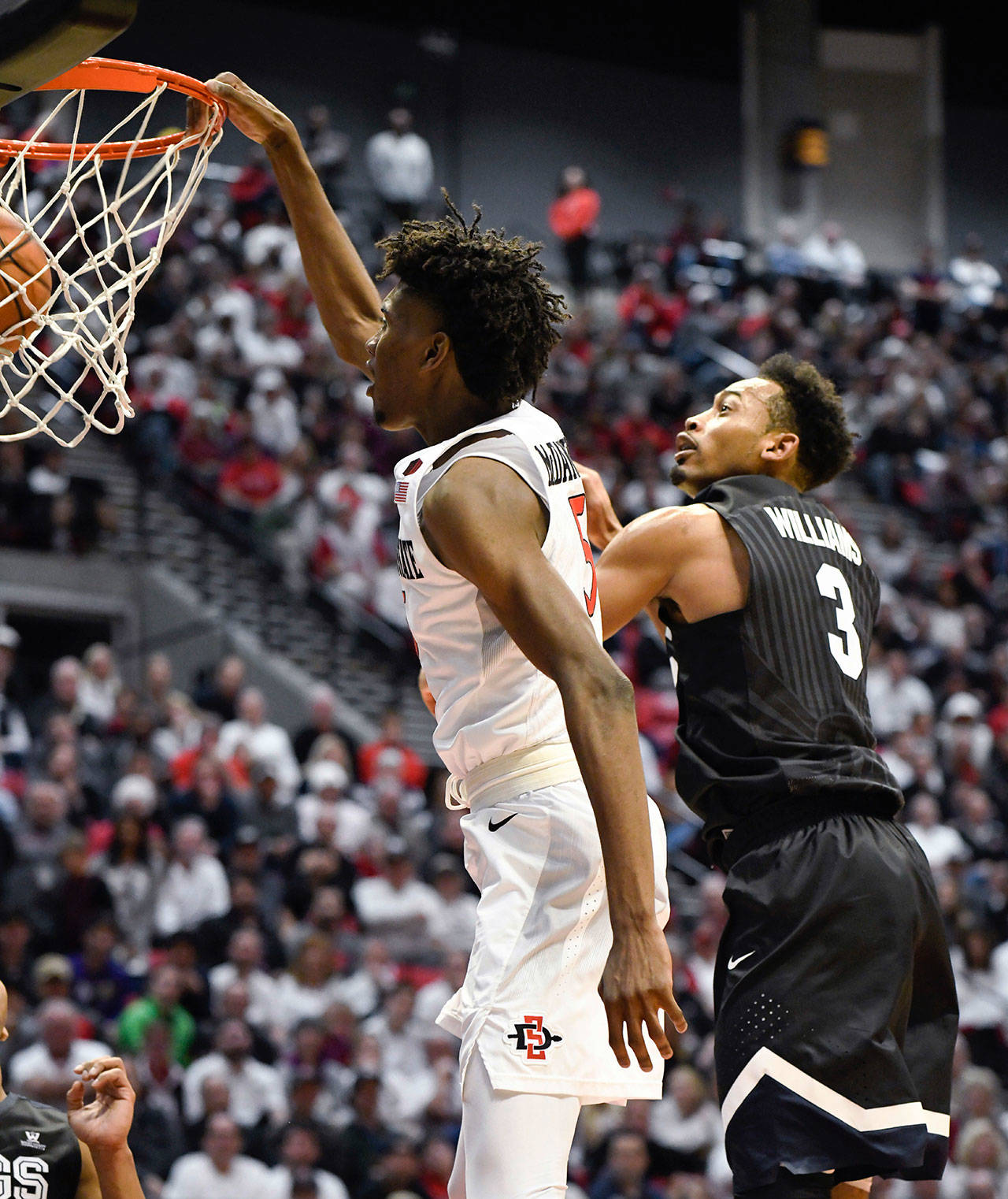 San Diego State forward Jalen McDaniels (5) tips in a rebound in front of Gonzaga forward Johnathan Williams (3) during the second half of a game Thursday in San Diego. (AP Photo/Denis Poroy)
