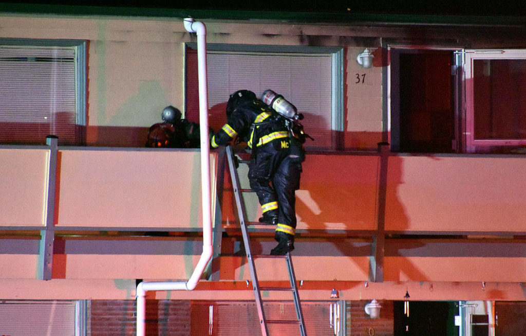Two people were injured, one critically, at an apartment building fire in Everett Thursday night. One was hurt from jumping off a balcony to escape flames. (Caleb Hutton / The Herald)
