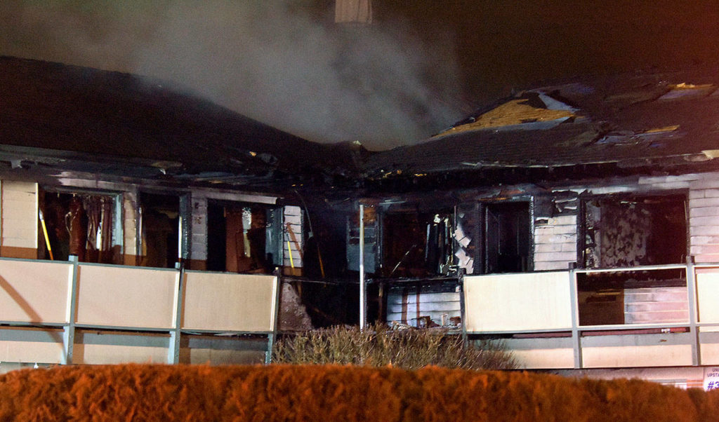 Much of the smoke and flames at Colby Square Apartments in Everett Thursday night were centered near the bend in the L-shaped building. (Caleb Hutton / The Herald)
