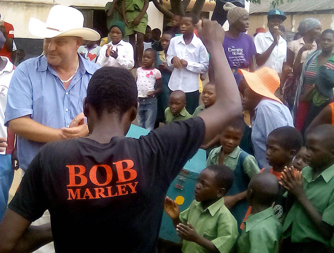 Farmer Darryn Smart (left) and his family are welcomed back to their farm, Lesbury, by workers and community members Thursday in Tandi, Zimbabwe. (AP Photo/Farai Musaka)