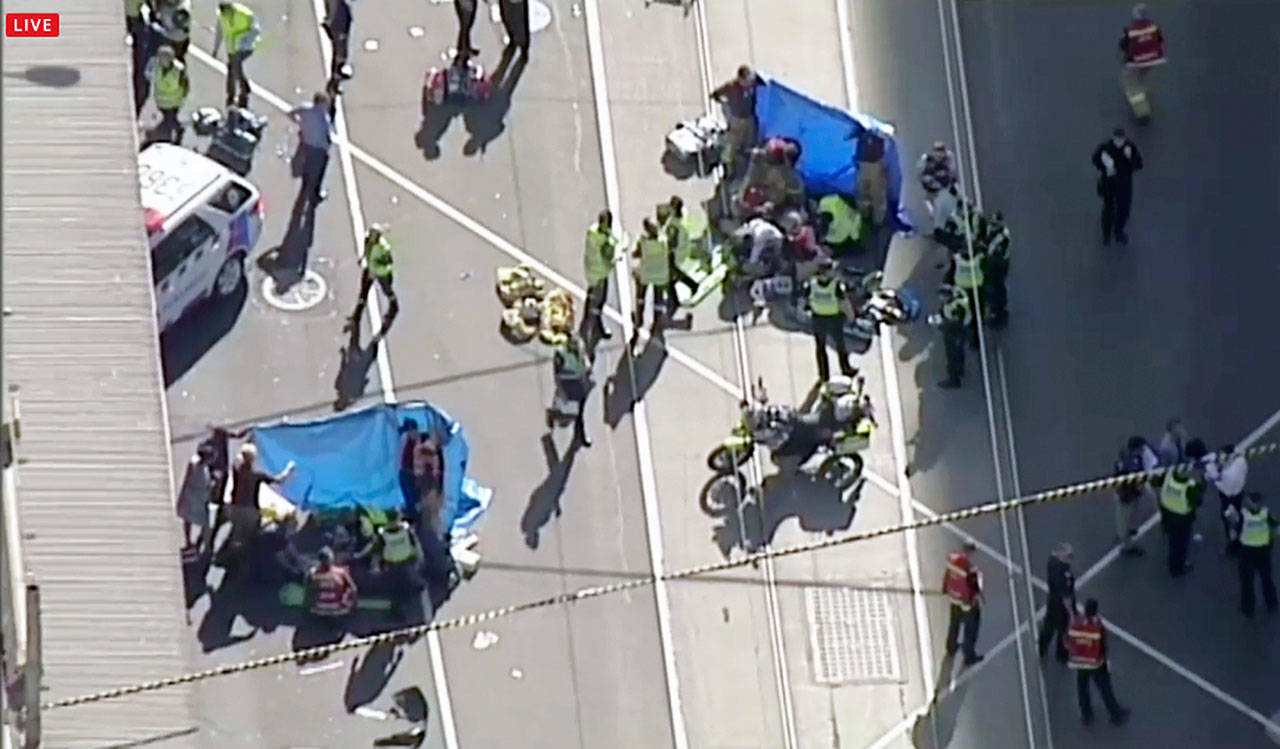 Emergency medical workers offer aid to victims struck by a vehicle in Melbourne, Australia, on Thursday. (Australian Broadcast Corp. via AP, File)