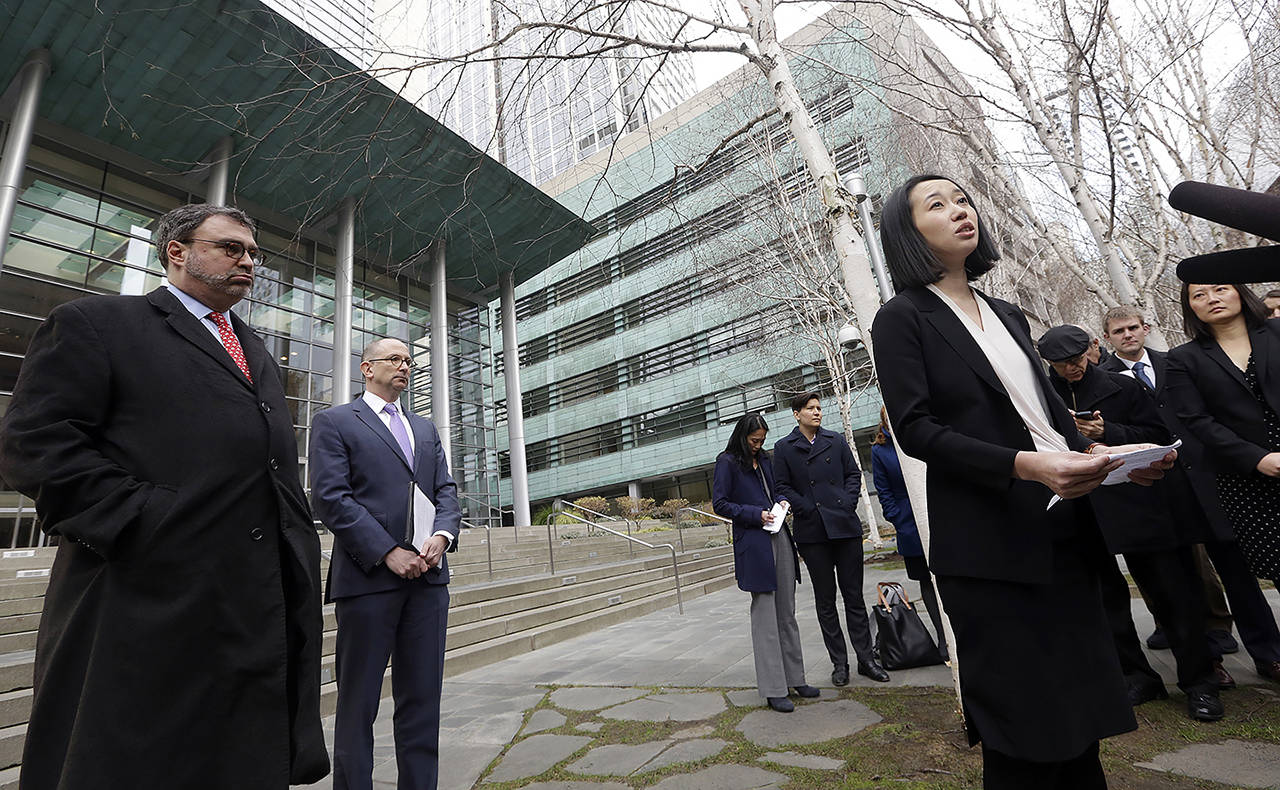 Mariko Hirose (right), a litigation director at the Urban Justice Center, speaks to reporters accompanied by Mark Hetfield, president & CEO of HIAS (left) and Rabbi Will Berkowitz, Jewish Family Service of Seattle CEO, in front of a federal courthouse on Dec. 21 in Seattle. (AP Photo/Elaine Thompson)