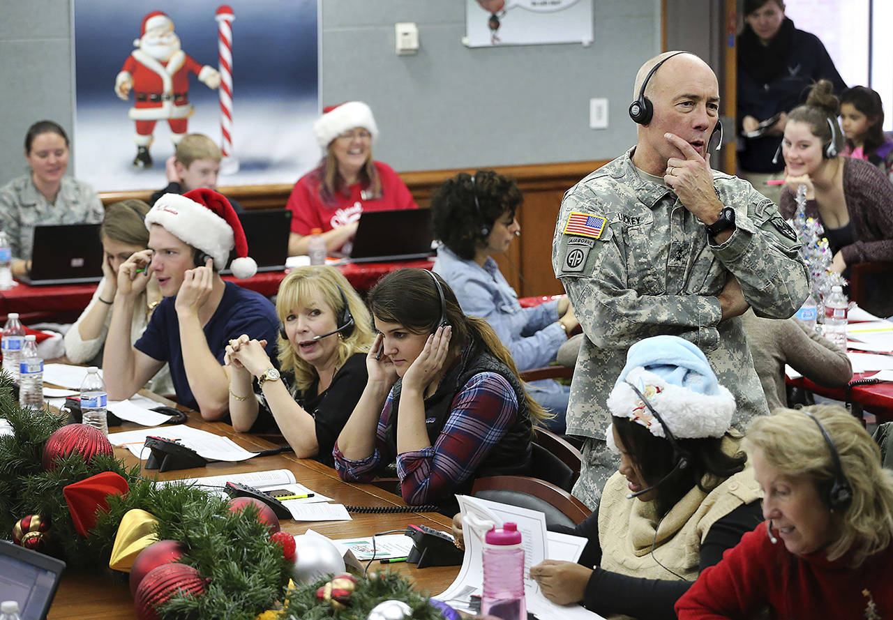 In this Dec. 24, 2014, photo, NORAD and USNORTHCOM Chief of Staff Maj. Gen. Charles D. Luckey joins other volunteers taking phone calls from children around the world asking where Santa is and when he will deliver presents to their homes, inside a phone-in center during the annual NORAD Tracks Santa Operation, at the North American Aerospace Defense Command, at Peterson Air Force Base, Colorado. (AP Photo/Brennan Linsley, File)