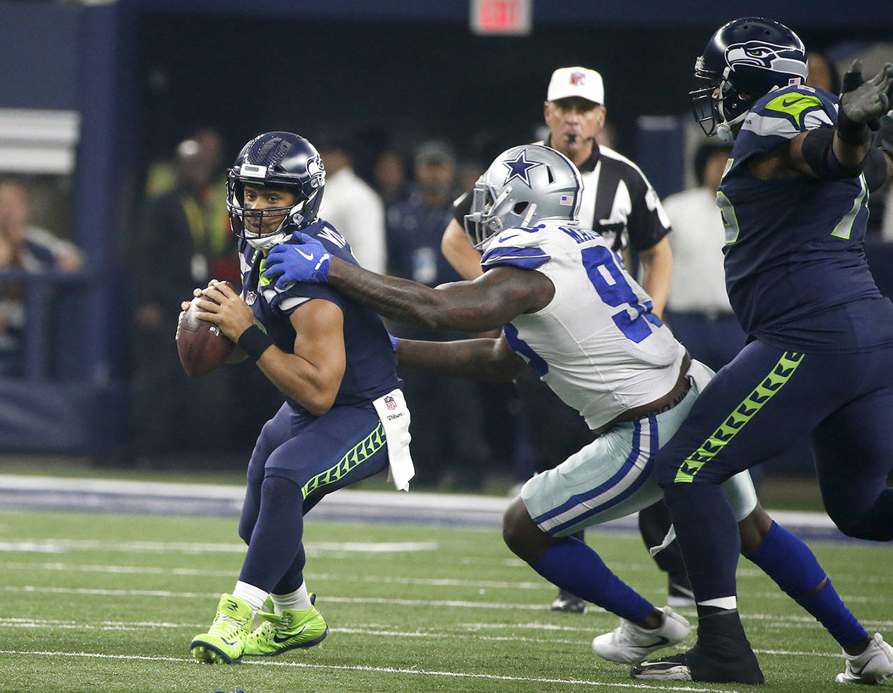 Dallas Cowboys defensive end Benson Mayowa (left) sacks Seattle Seahawks quarterback Russell Wilson (3) as Duane Brown (76) watches in the first half of an NFL football game Sunday in Arlington, Texas. (AP Photo/Michael Ainsworth)