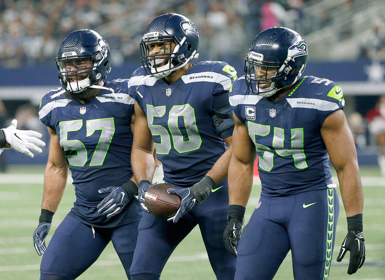 Seattle’s K.J. Wright (50) celebrates his interception that preserved the Seahawks’ lead in the third quarter of a 21-12 victory over Dallas on Sunday in Arlington, Texas. (AP Photo/Michael Ainsworth)