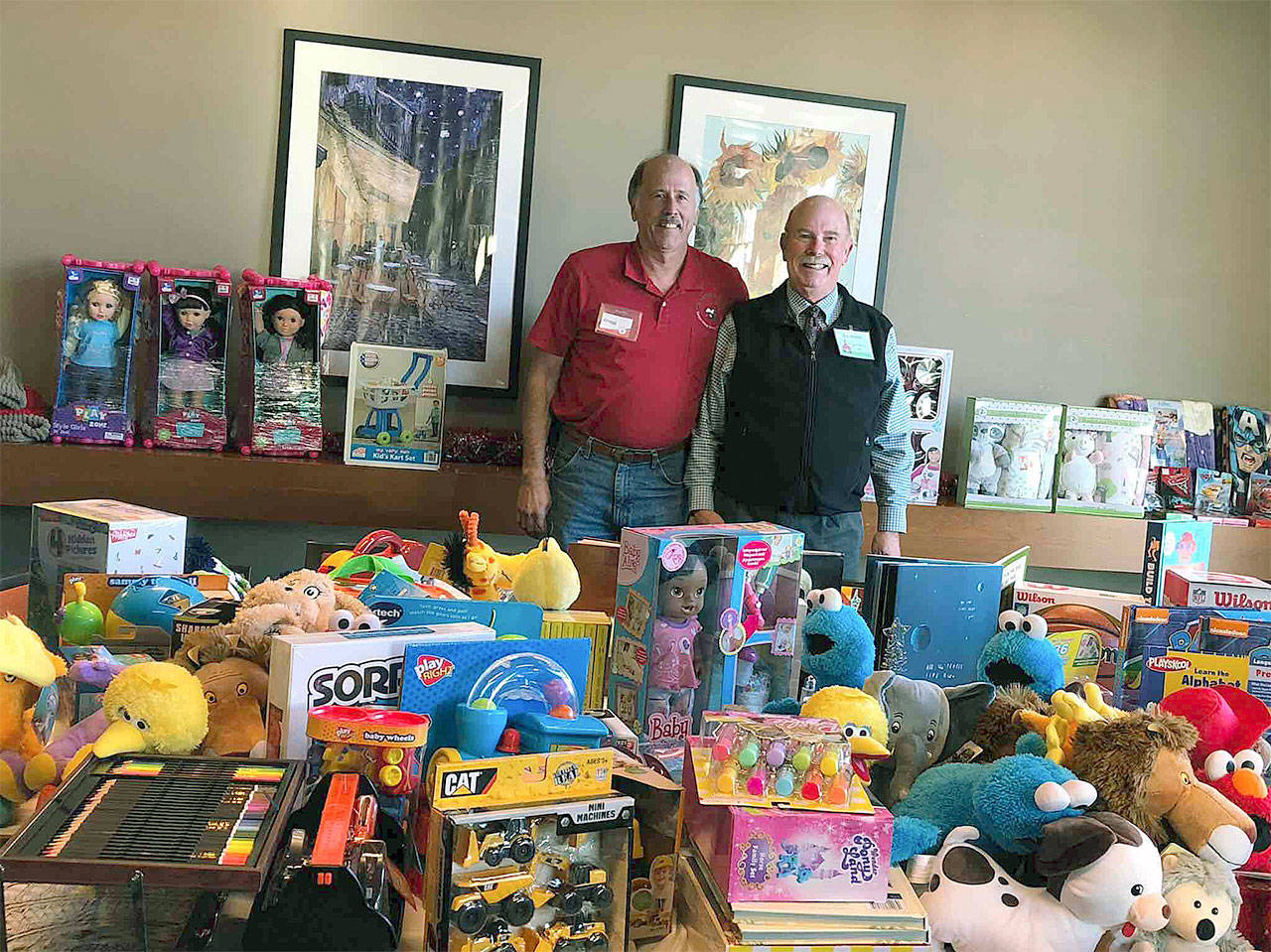 Gregg Millne, president of Christmas House, thanks Ken Harvey of the Sno-Isle School Retirees’ Association for the organization’s donation of toys and $598. (Contributed photo)