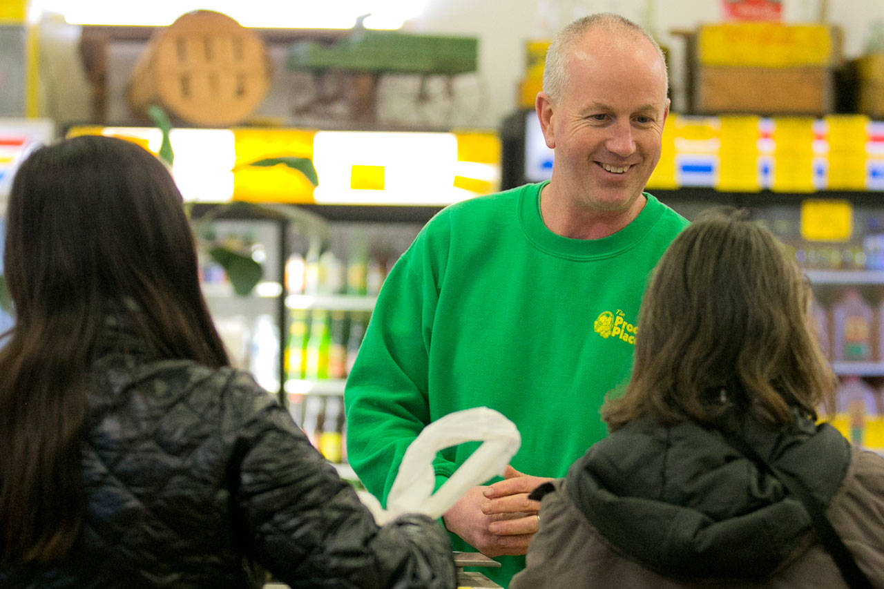 Joe Freed completes a sale Thursday night at Produce Place in Marysville. The popular market will be closing in January to find a new location. (Kevin Clark / The Daily Herald)