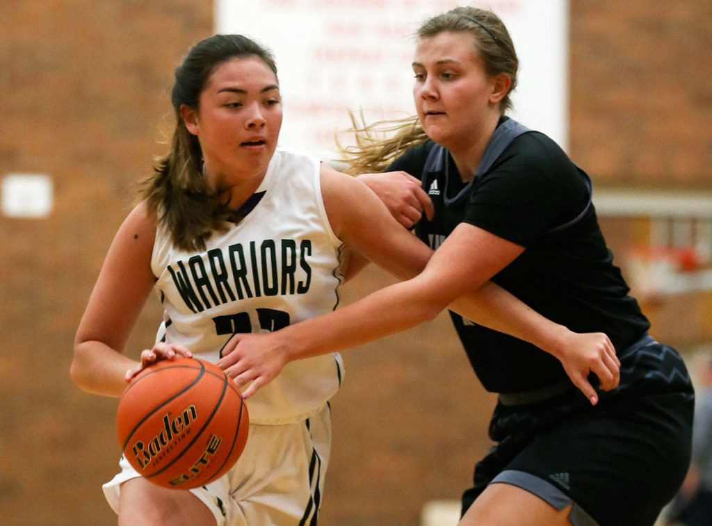 Edmonds-Woodway’s Maddie McMahon dribbles past Union’s Courtney Cranston during a game Dec. 27, 2017, at Mountlake Terrace High School. (Kevin Clark / The Herald)
