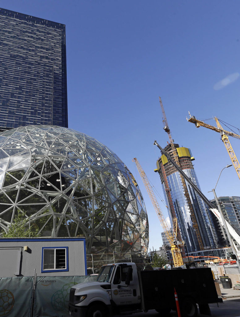 In this Oct. 11 photo, large spheres take shape in front of an existing Amazon building (behind) as new construction continues across the street in Seattle. (AP Photo/Elaine Thompson)
