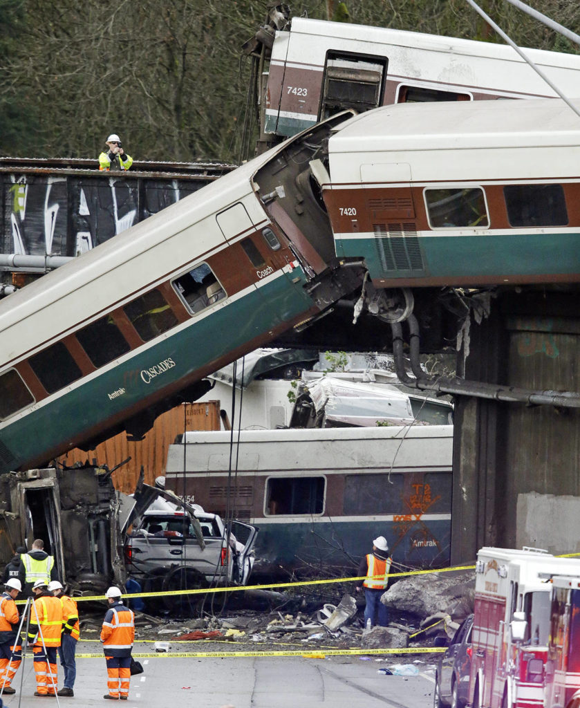 Cars from an Amtrak train that derailed above lay spilled onto I-5 alongside smashed vehicles Dec. 18 in DuPont. (AP Photo/Elaine Thompson)
