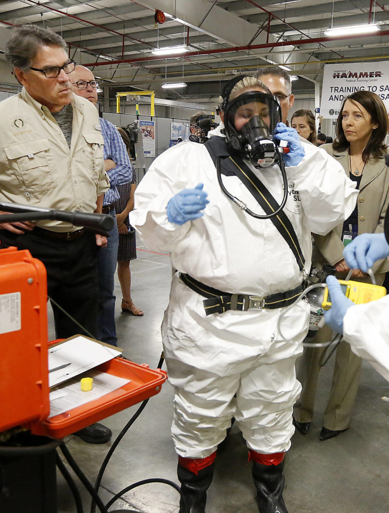 In this Aug. 15 photo, Energy Secretary Rick Perry (left) observes as worker trainer Joni Spencer prepares to give a respirator demonstration at the HAMMER Training Facility in Richland. (Bob Brawdy/Tri-City Herald via AP, File)
