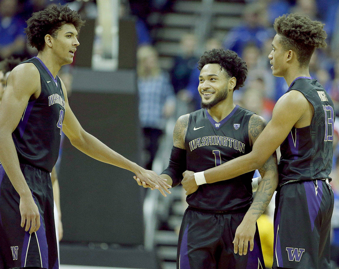 Washington’s David Crisp (center) Matisse Thybulle (left) and Hameir Wright celebrate during the Huskies’ win over Kansas on Dec. 6 in Kansas City, Mo. UW begins Pac-12 play Friday against USC. (AP Photo/Charlie Riedel)