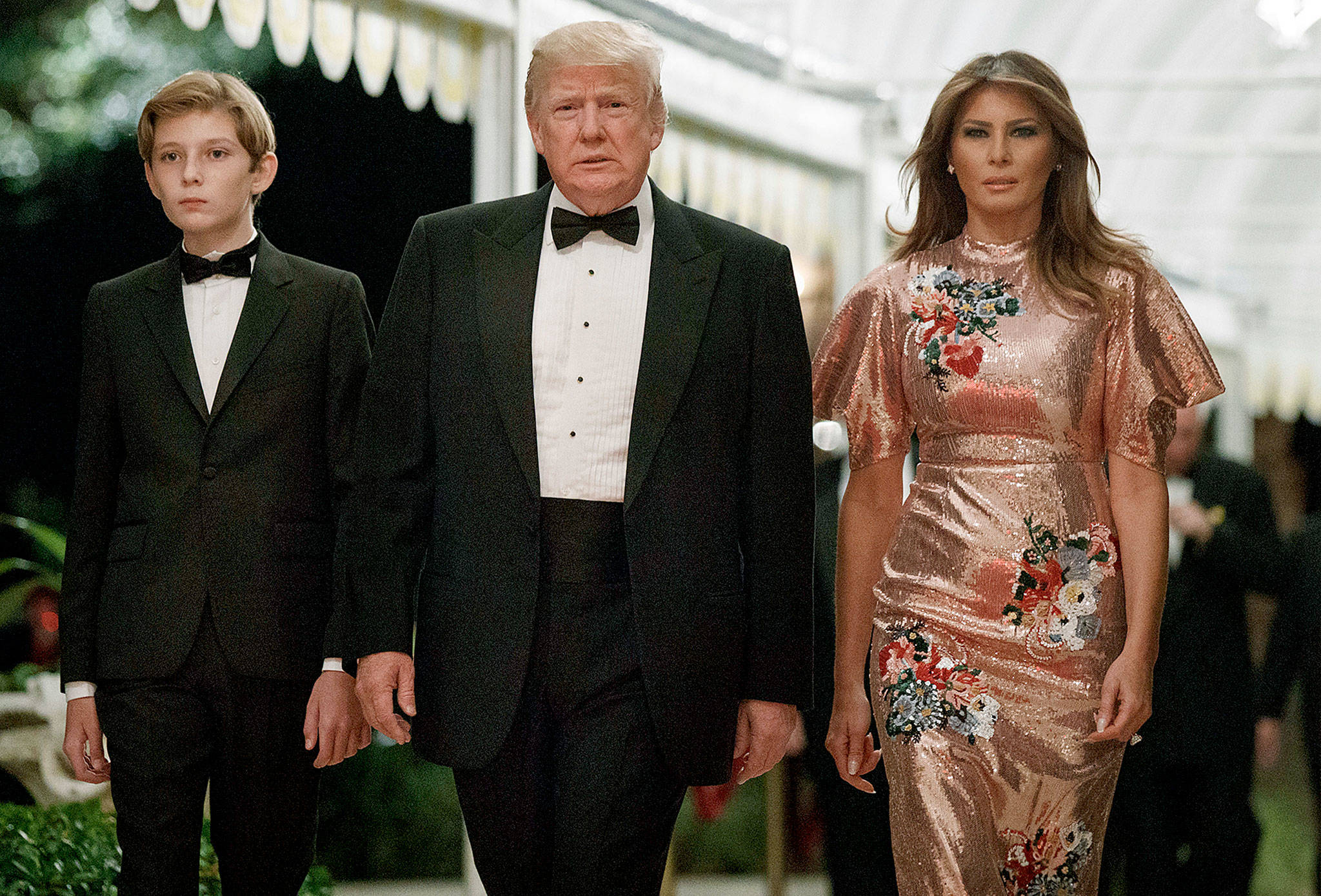 President Donald Trump arrives for a New Year’s Eve gala at his Mar-a-Lago resort with first lady Melania Trump and their son, Barron, on Sunday in Palm Beach, Florida. (AP Photo/Evan Vucci)