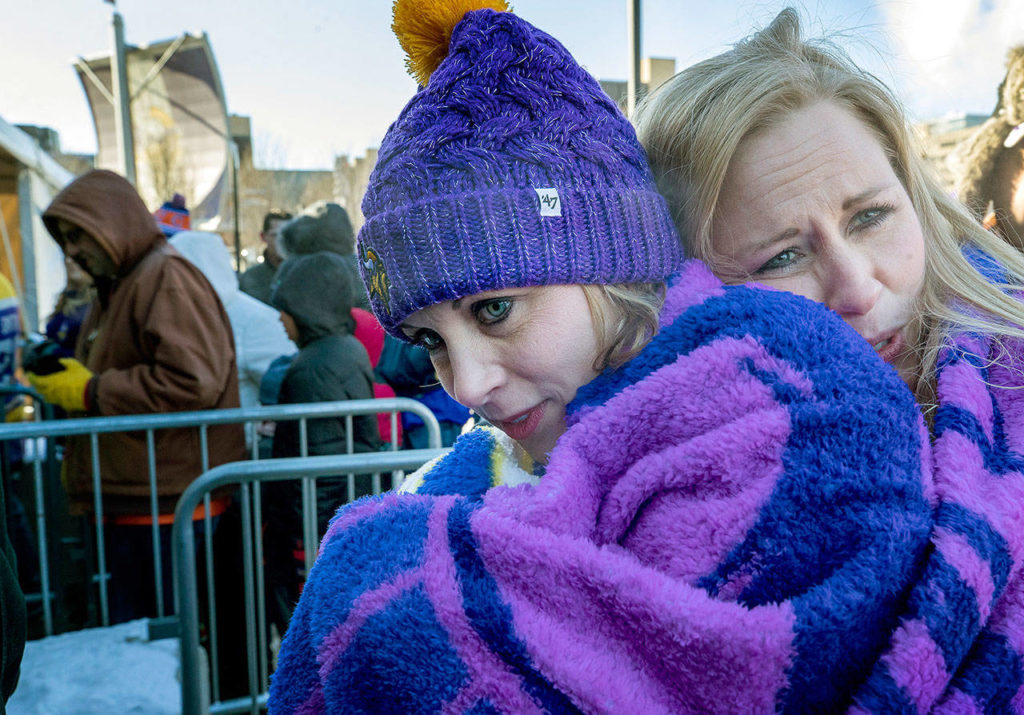 April Nickila and Christina Liesmaki try to stay warm while waiting in subzero temperatures to enter U.S. Bank Stadium to watch an NFL football game between the Chicago Bears and Minnesota Vikings on Sunday in Minneapolis. (Carlos Gonzalez / Star Tribune)
