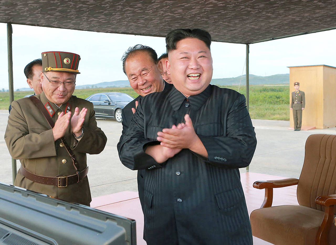 In this undated photo, North Korean leader Kim Jong Un (right) celebrates what was said to be the test launch of an intermediate range Hwasong-12 missile at an undisclosed location in North Korea. (Korean Central News Agency/Korea News Service via AP, File)