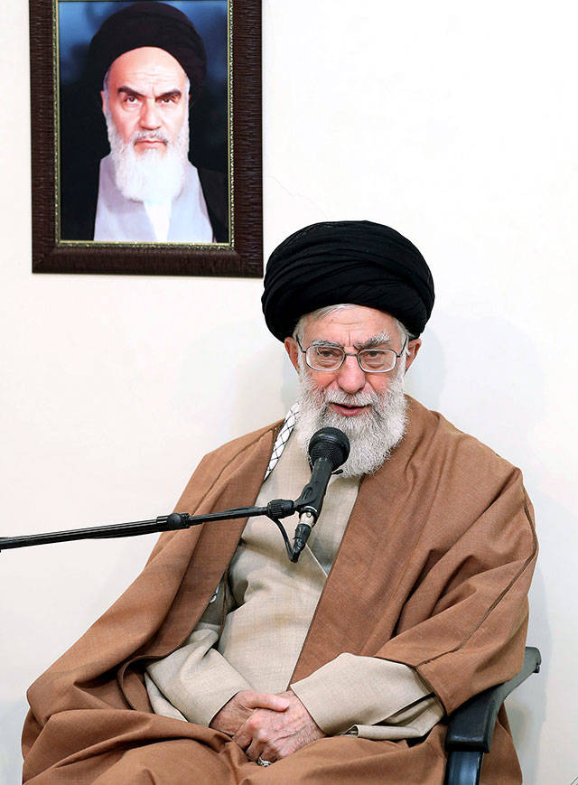 Supreme Leader Ayatollah Ali Khamenei speaks in a meeting under a portrait of the late Iranian revolutionary founder Ayatollah Khomeini in Tehran, Iran, on Tuesday. (Office of the Iranian Supreme Leader via AP)