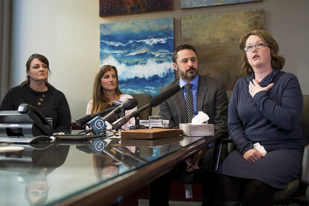 Arica Smith-Simmer (right), a parent of two children at Sky Valley Education Center, gives an account of her health issues as Jill Savery (from left), Stacy Mullen-Deland and attorney Sean Gamble listen during a press conference in downtown Seattle on Wednesday. (David Rzegocki)
