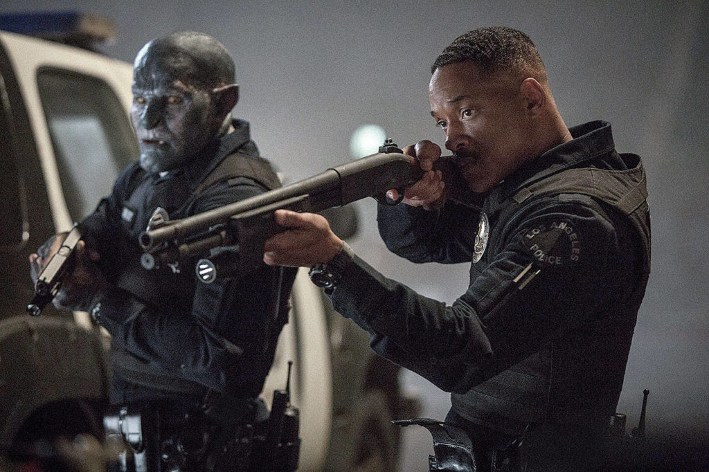 Will Smith, right, and Joel Edgerton, unrecognizable under layers of blue makeup, play unhappily paired cops in “Bright.” (Matt Kennedy/Netflix)
