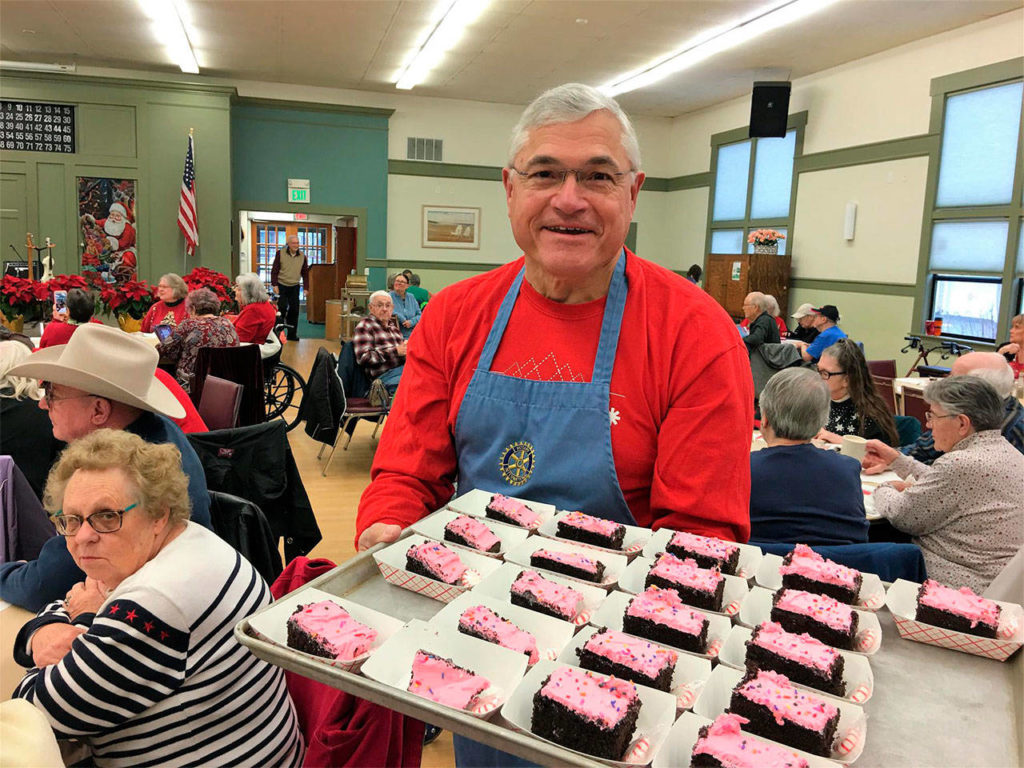 Arlington Rotary volunteer Dale Duskin serves cake to seniors at the Stillaguamish Senior Center on Dec. 15. (Contributed photo)
