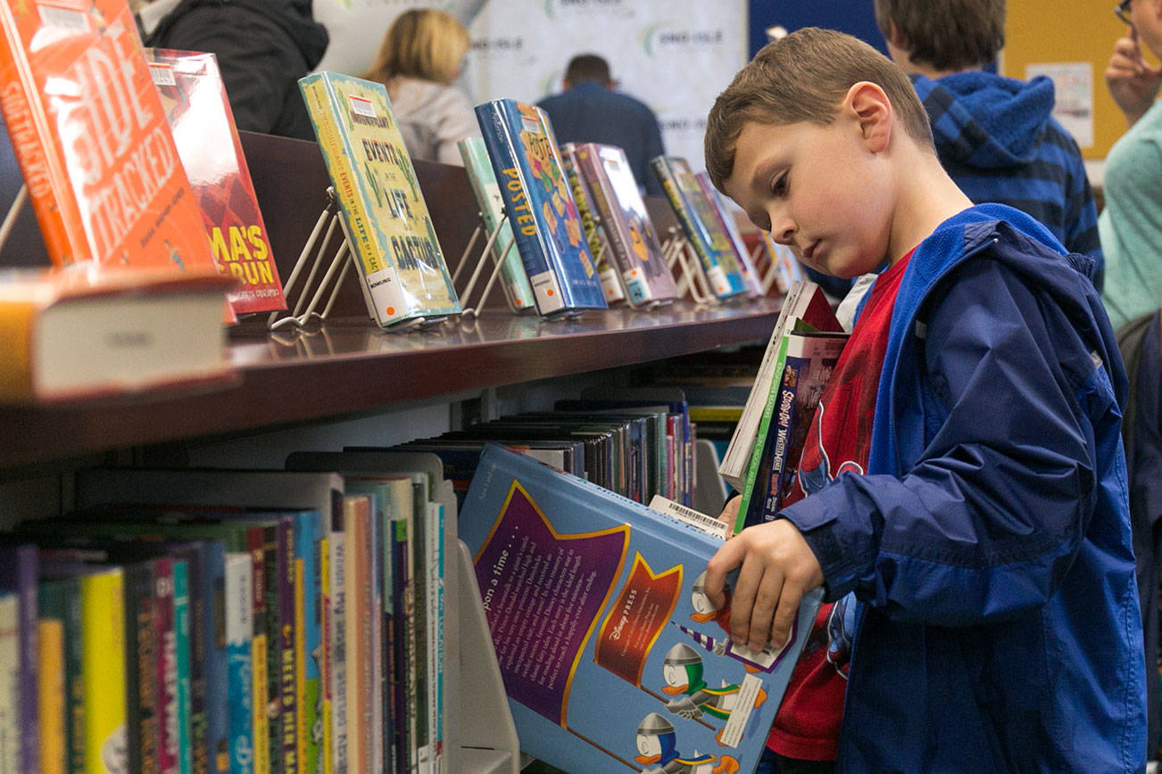 Jackson Eyman, 7, browses a shelf during the grand opening of the new Lakewood/Smokey Point Library Saturday morning in Arlington on January 6, 2018. (Kevin Clark / The Daily Herald)