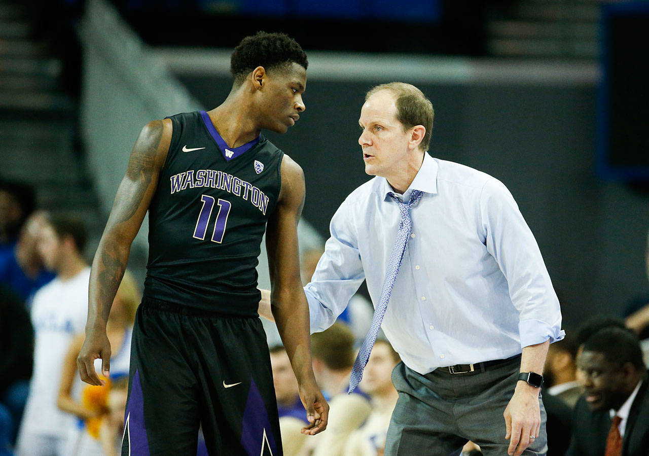 Washington head coach Mike Hopkins and forward Nahziah Carter (11) talk during a game against UCLA on Dec. 31 in Los Angeles. (AP Photo/Ringo H.W. Chiu)