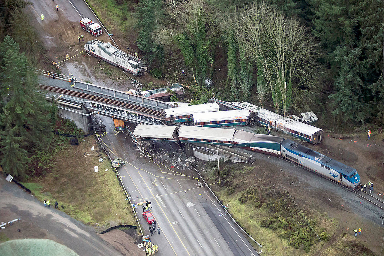 Cars from an Amtrak train that derailed lie spilled onto I-5 in DuPont on Dec. 18. (Bettina Hansen/The Seattle Times)