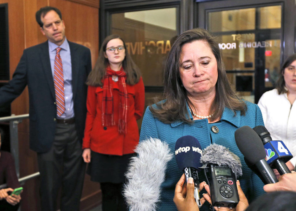 Democratic candidate for the 94th House of Delegates seat, Shelly Simonds (right), speaks to the media as her husband, Paul Danehy (left), and daughter Georgia Danehy (center) look on after a drawing to determine the winner of a tied election at the Capitol in Richmond, Virginia, on Thursday. Republican Delegate David Yancey won the drawing. (AP Photo/Steve Helber)
