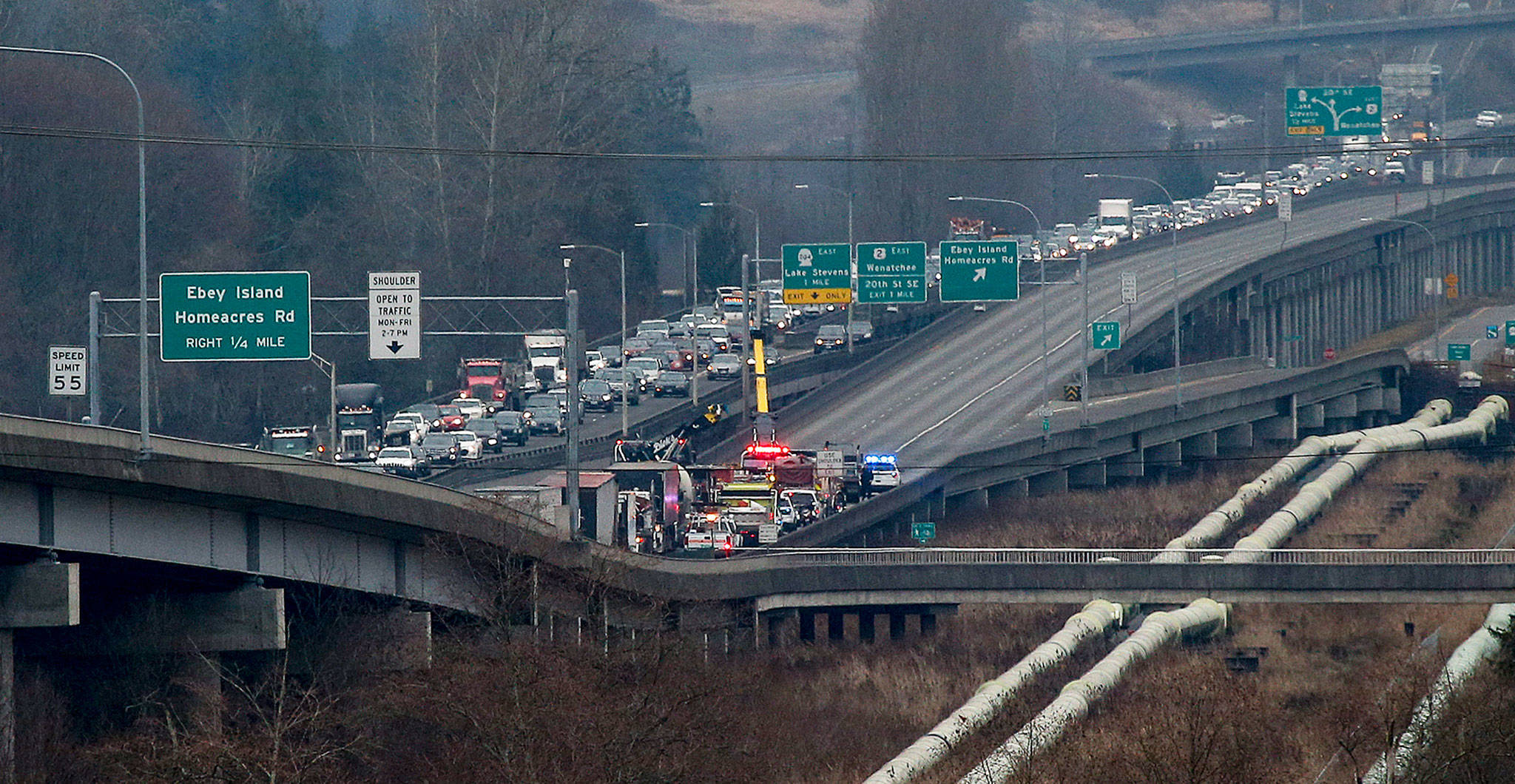 The eastbound lanes of U.S. 2 on the trestle near Everett were blocked when a dump truck pulling a trailer rolled over on Thursday. (Ian Terry / The Herald)