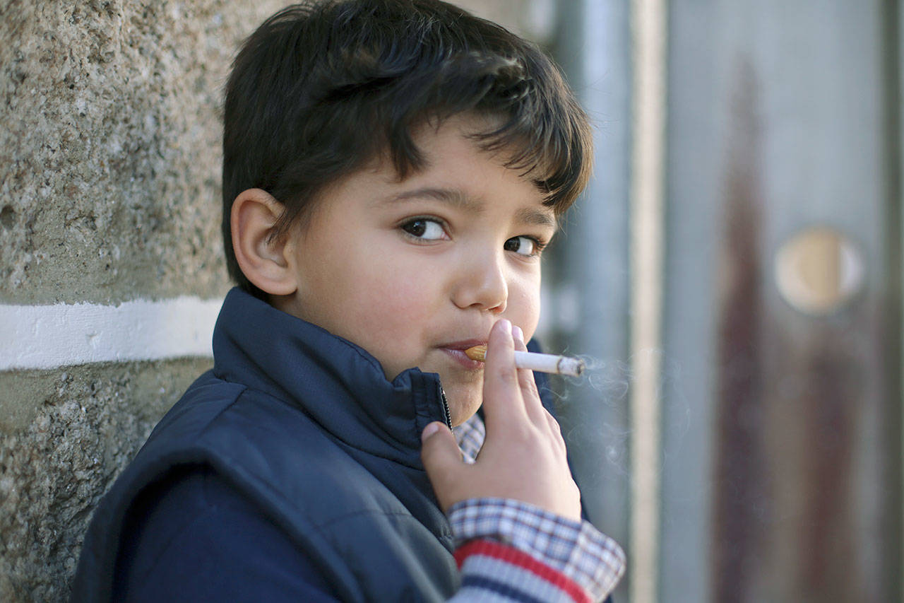 Fernando, 6, smokes a cigarette Saturday in the village of Vale de Salgueiro, northern Portugal, during the local Kings’ Feast. The village’s Epiphany celebrations, called Kings’ Feast, feature a tradition that each year causes an outcry among outsiders: parents encourage their children, some as young as 5, to smoke cigarettes. Parents buy the packs of cigarettes for their children. Locals say the practice is centuries-old, but nobody is sure what it symbolizes nor why the children are incited to smoke. (AP Photo/Armando Franca)