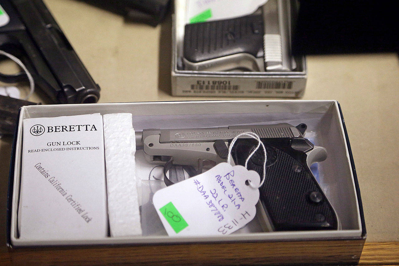 A Beretta pistol being sold on behalf of the Aberdeen Police Department sits in a gun case before an auction at Johnny’s Auction House, where the company handles gun sales for a half-dozen police departments and the Lewis County Sheriff’s Office, in Rochester. (AP Photo/Elaine Thompson)