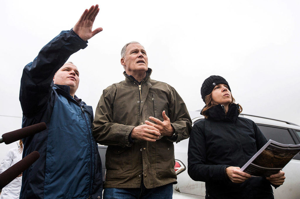 Jeff Emmons (left), director of the Yakima Valley Office of Emergency Management, speaks as Washington Gov. Jay Inslee (center) and Commissioner of Public Lands Hilary Franz listen on Sunday during a news conference near Union Gap. (Jake Parrish/Yakima Herald-Republic via AP) 
