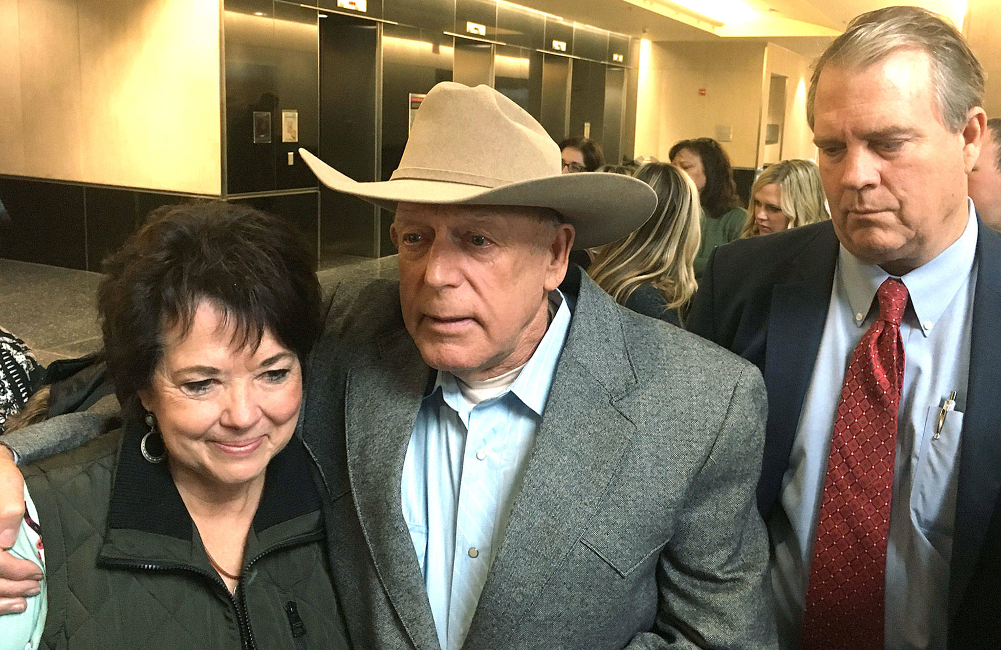 Rancher and states’ rights figure Cliven Bundy (center) emerges from court on Monday a free man, flanked by his wife, Carol Bundy and attorney Bret Whipple, at the U.S. District Court building in Las Vegas. (AP Photo/Ken Ritter)