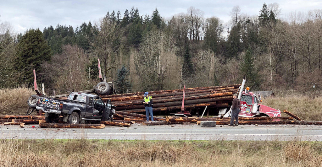 A log truck rolled onto cars in a collision that caused serious injuries and shut down U.S. 2 on Monday morning near Snohomish. (Andy Bronson / The Herald)

