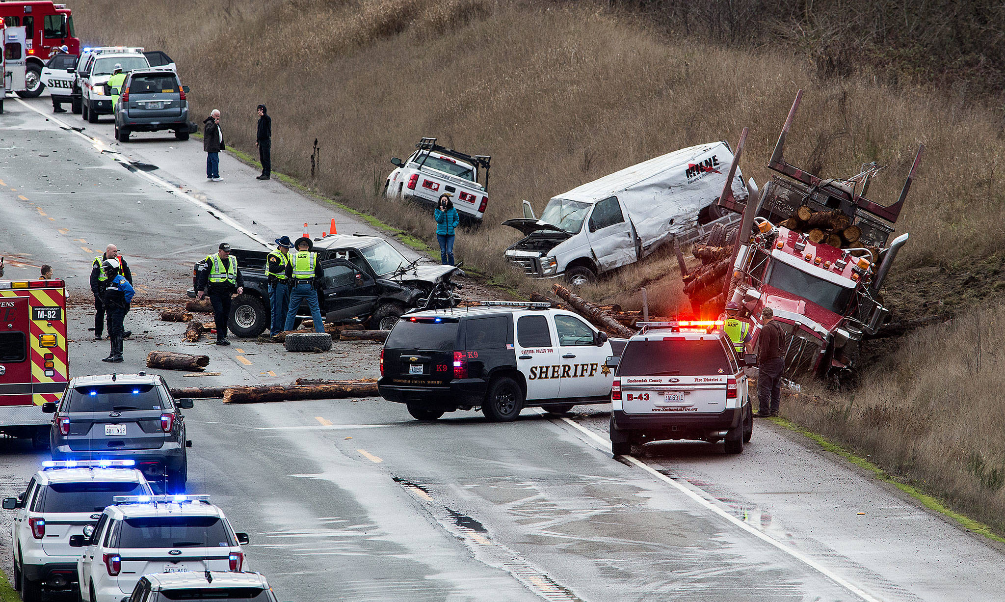 Law enforcement officers examine the area of a six-vehicle pileup on U.S. 2 that caused serious injuries and shut down the road in both directions on Monday near Snohomish. (Andy Bronson / The Herald)