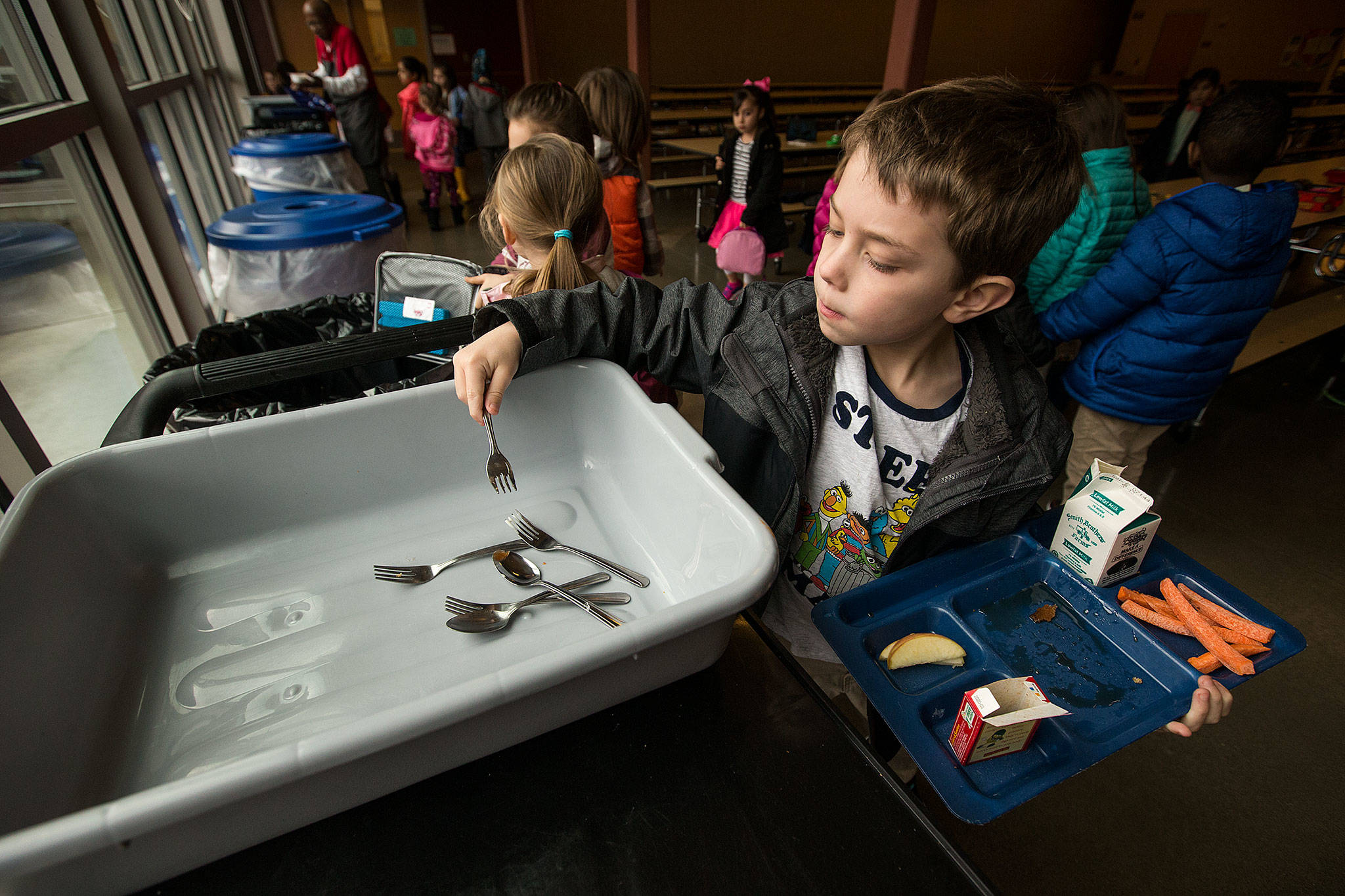 Kindergartner Austin Milton places his fork in a bin after eating lunch at Little Cedars Elementary on Jan. 10 in Snohomish. Little Cedars Elementary recently switched to reusable silverware to cut back on garbage. (Andy Bronson / The Herald)